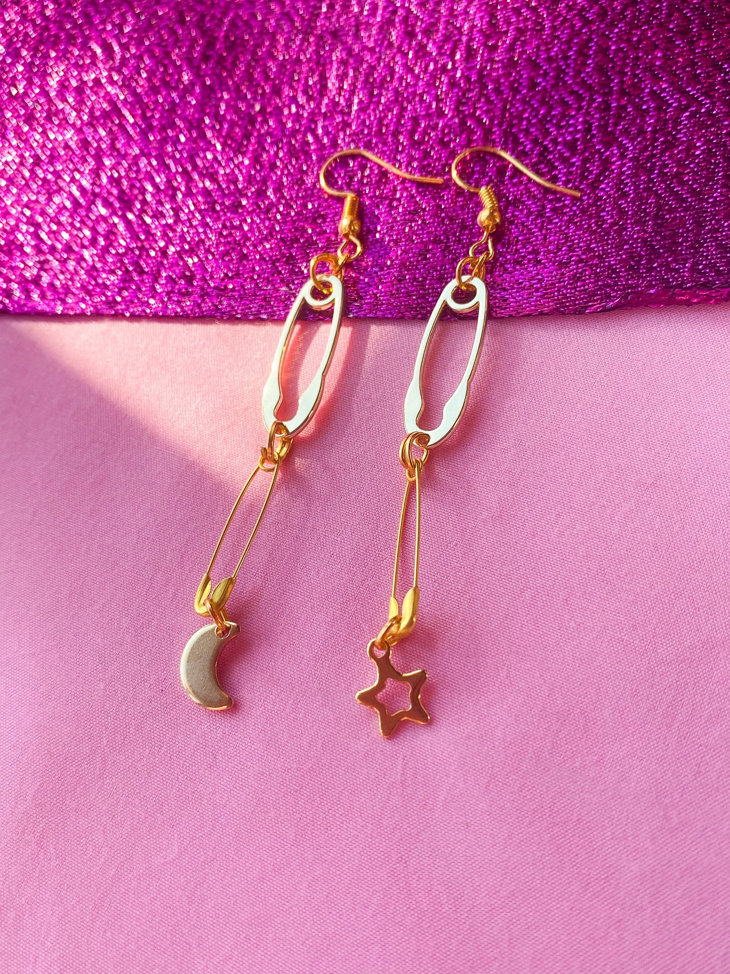 Gold safety pin with moon and star charm earrings Leftbians