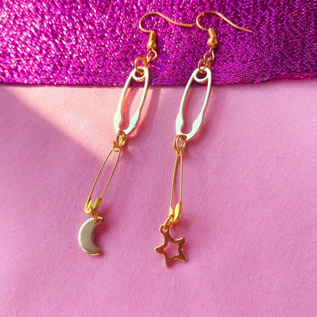 Gold safety pin with moon and star charm earrings Leftbians