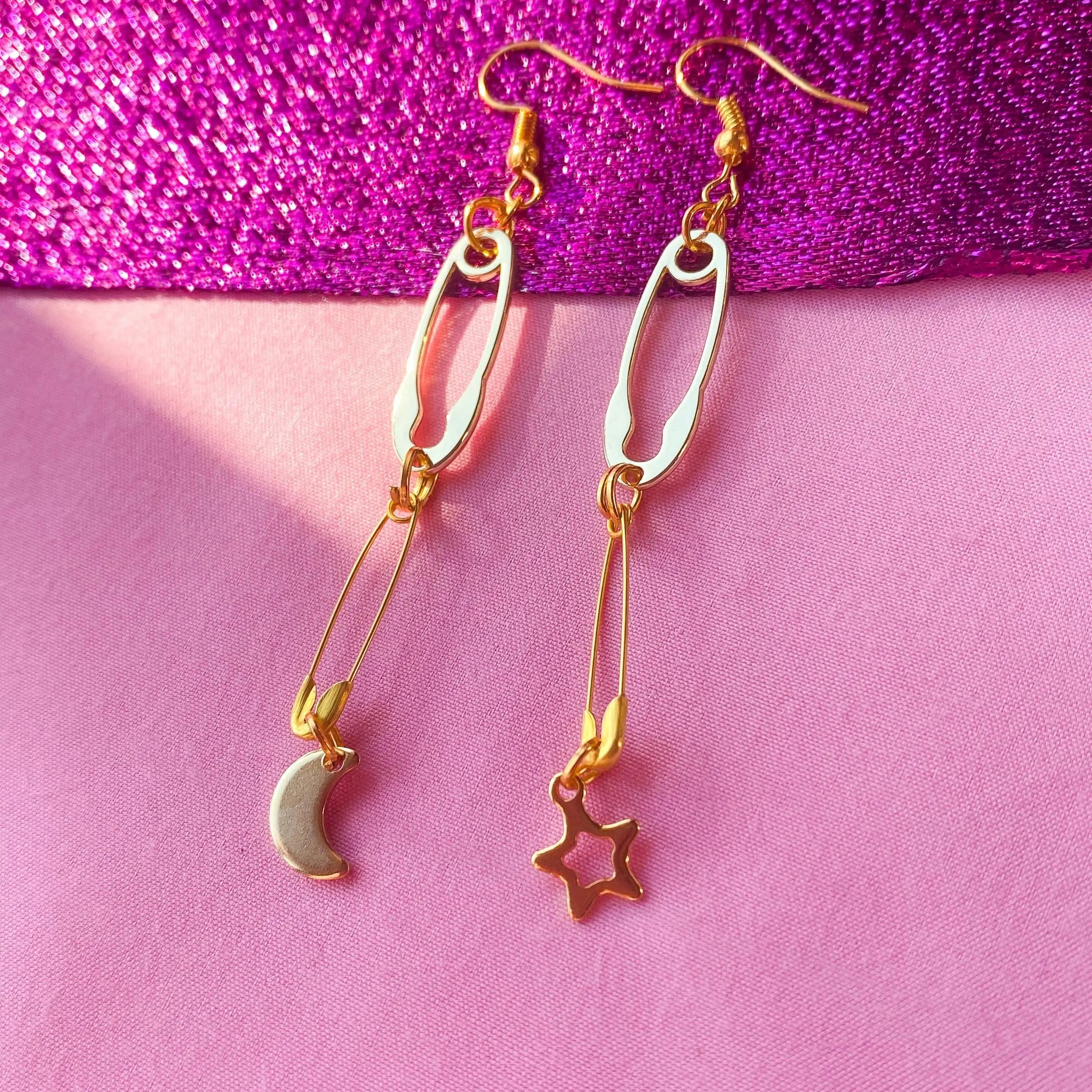 Gold safety pin with moon and star charm earrings Leftbians