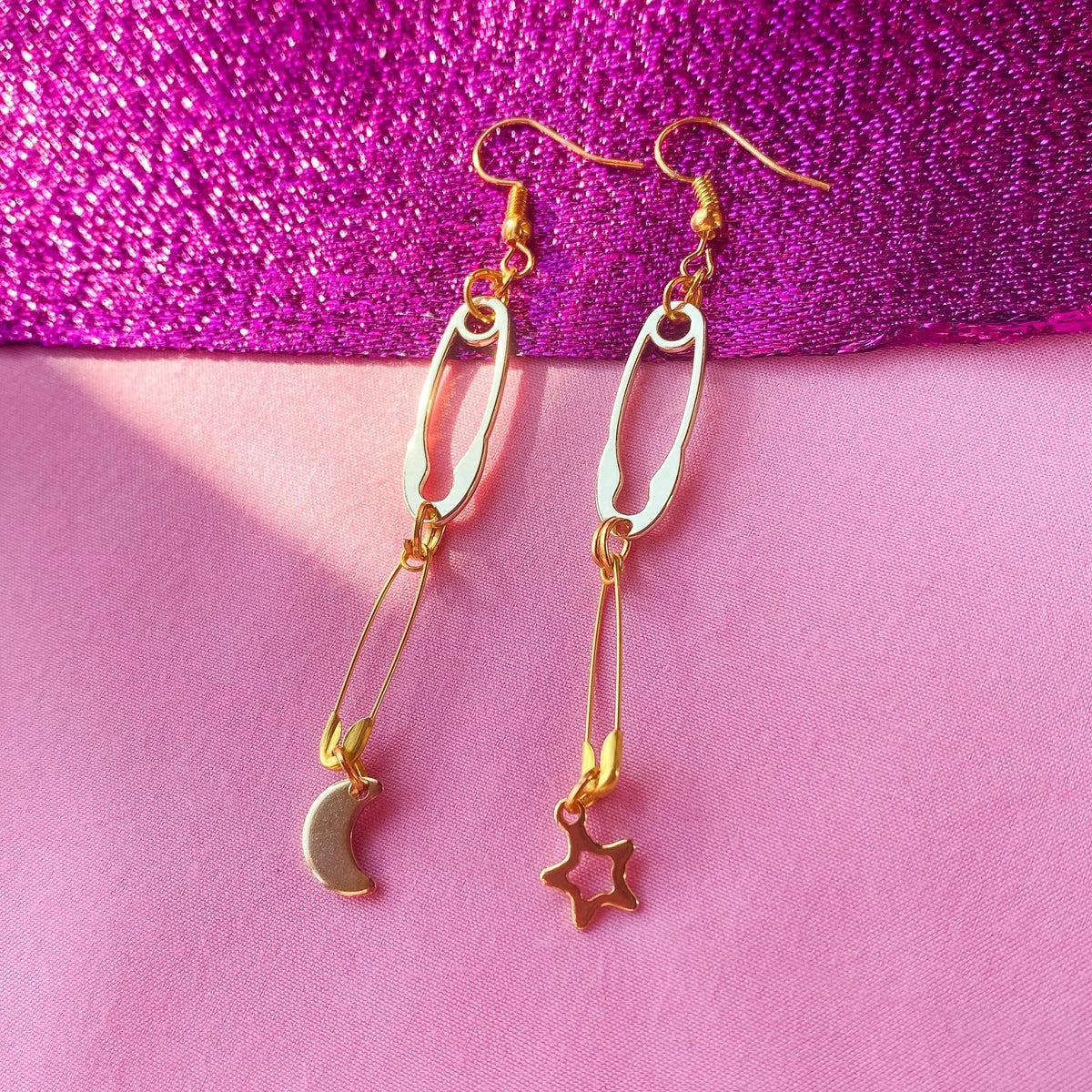Gold safety pin with moon and star charm earrings Leftbians
