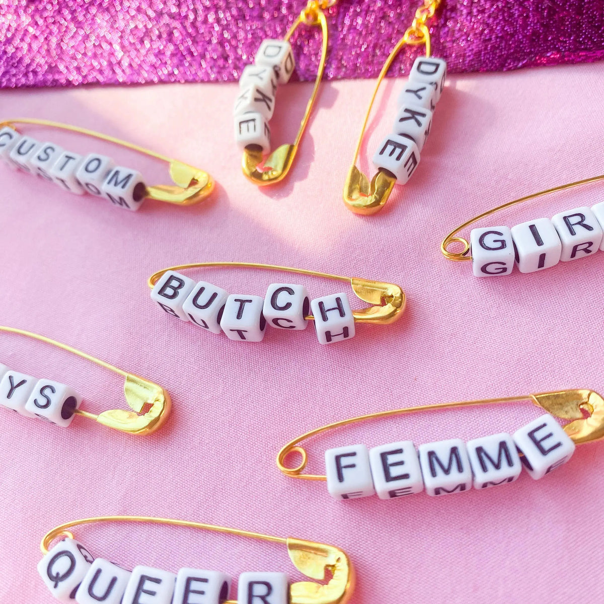 Gold safety pin word earrings Leftbians