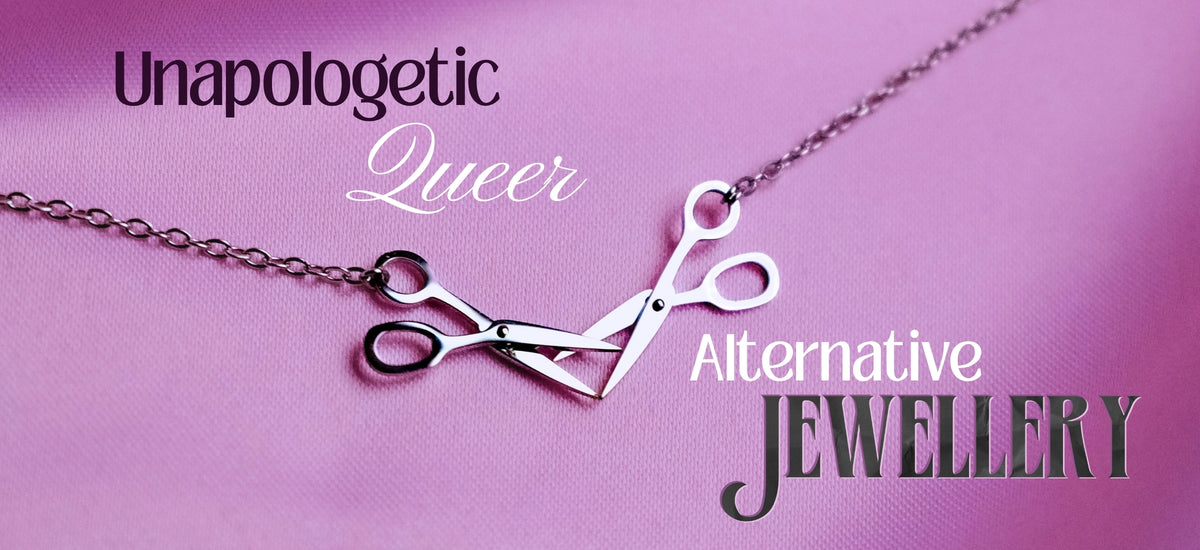 Scissor necklace on pink satin with the words Unapologetic Queer Alternative Jewellery