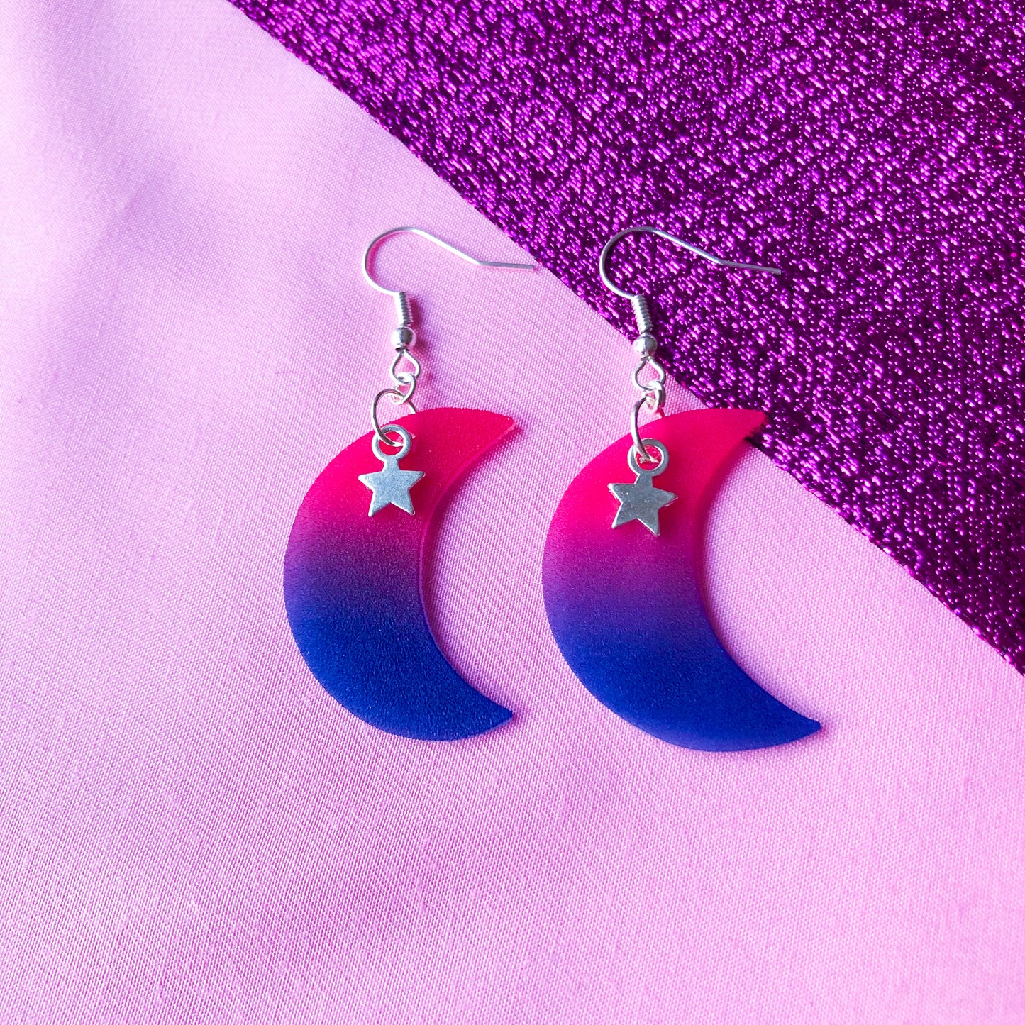 Crescent moon shrinky dink earrings in bisexual pride flag colours with a silver star charm at the top.