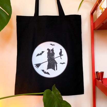 Gay witches on a broomstick, black tote bag